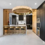 Black And Natural Wood Kitchen Cabinets With Gold Accents And Waterfall Wall Lights Luxury Renovation